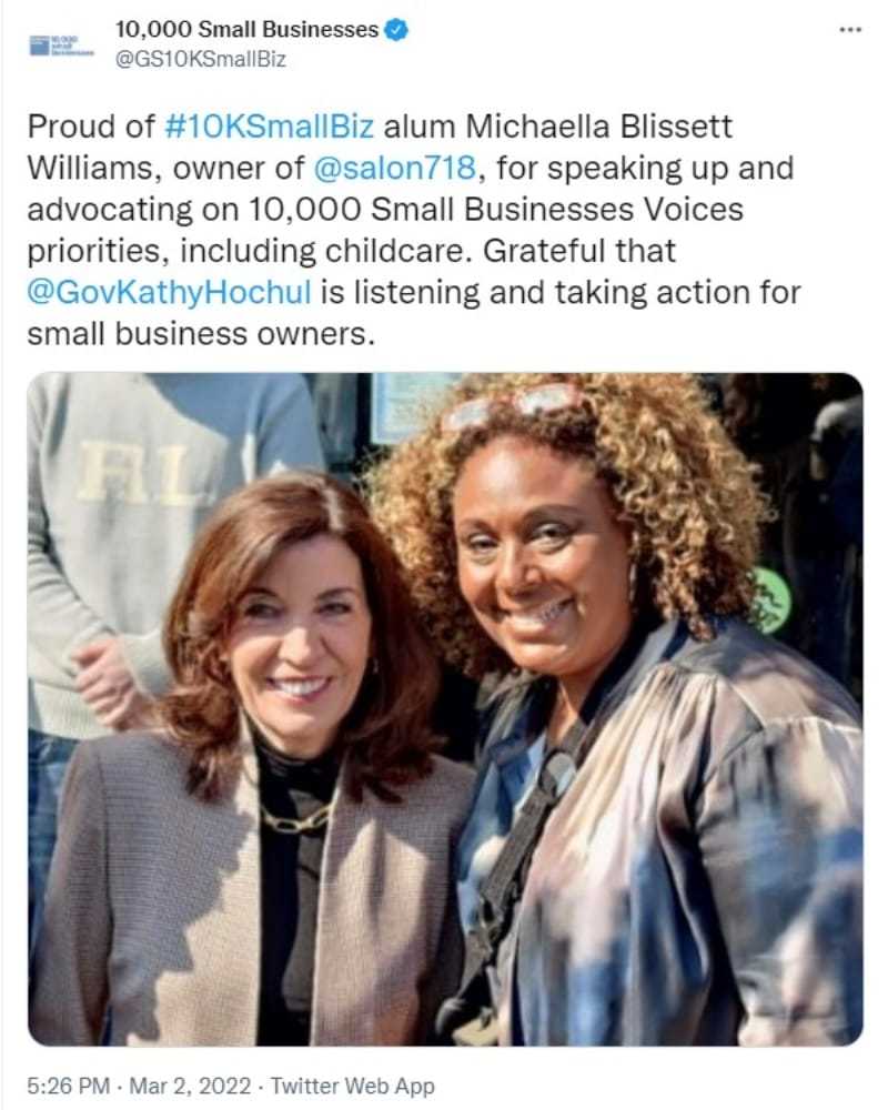 Two women smiling at a business event with supportive text overlay.