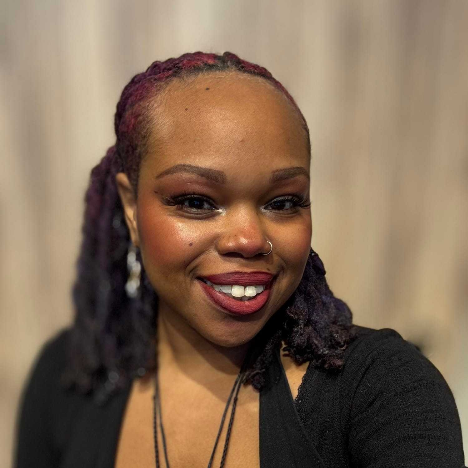 Portrait of Djenaba, a professional stylist at [salon] 718, showcasing their expertise and style.