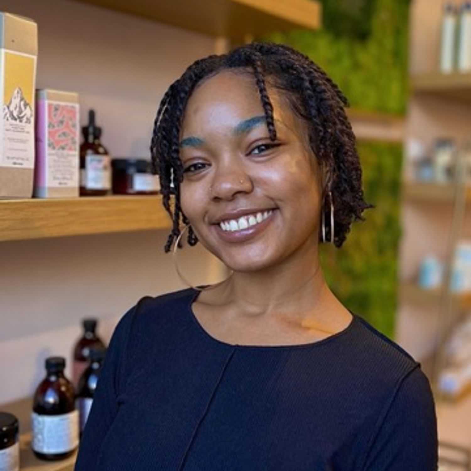 Portrait of Sydne, a professional stylist at [salon] 718, showcasing their expertise and style.