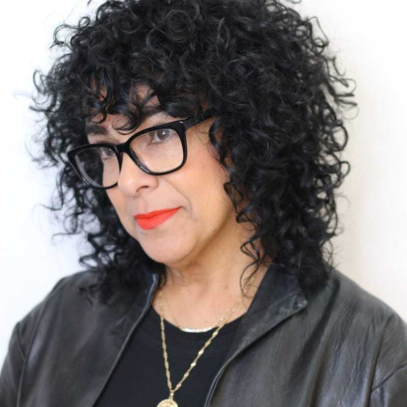 Portrait of Cynthia, a professional stylist at [salon] 718, showcasing their expertise and style.