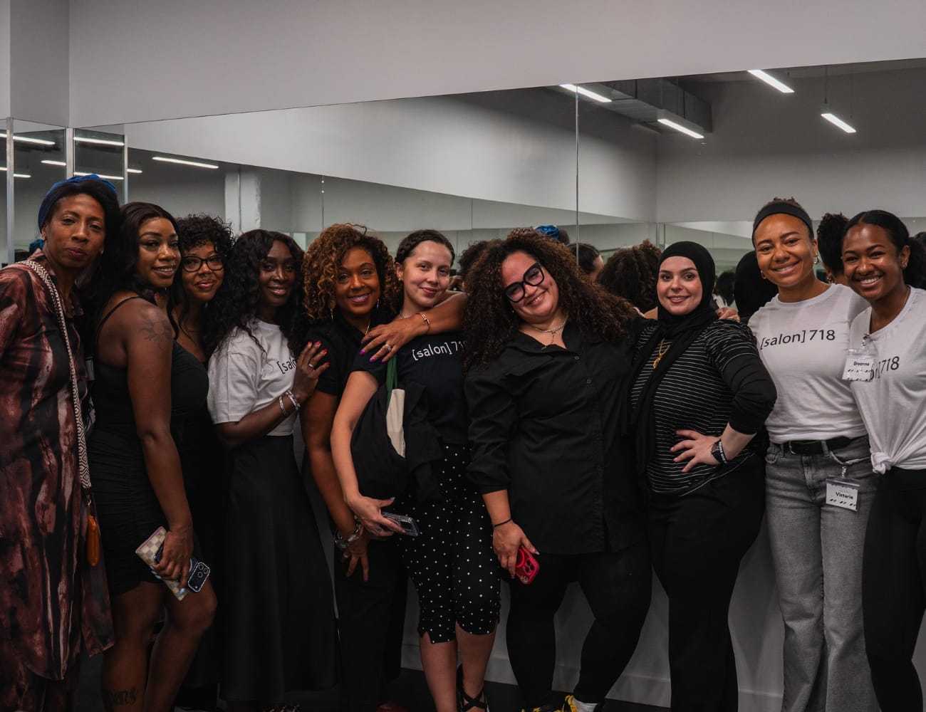 Group of people smiling together in a salon setting.