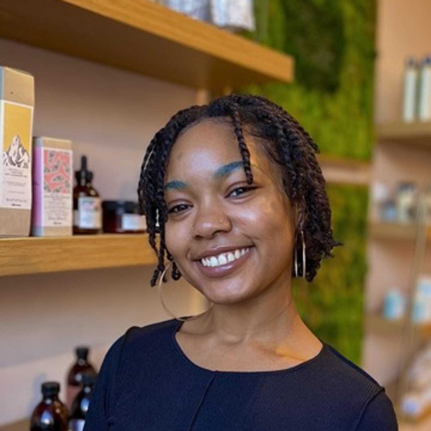 Portrait of Sydne, a professional stylist at [salon] 718, showcasing their expertise and style.