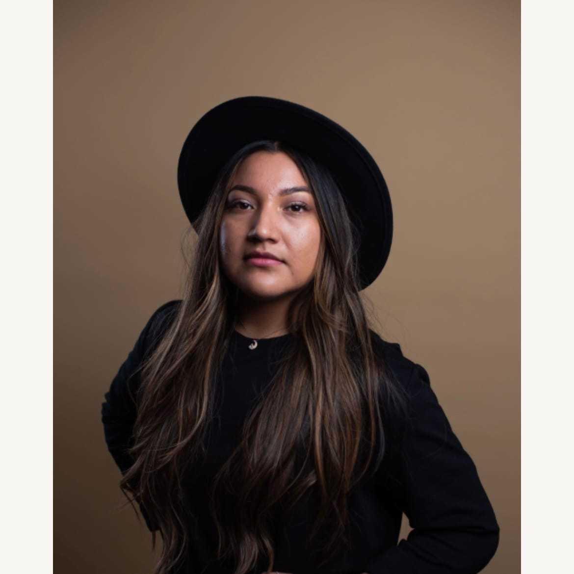 Portrait of Esmeralda, a professional stylist at [salon] 718, showcasing their expertise and style.