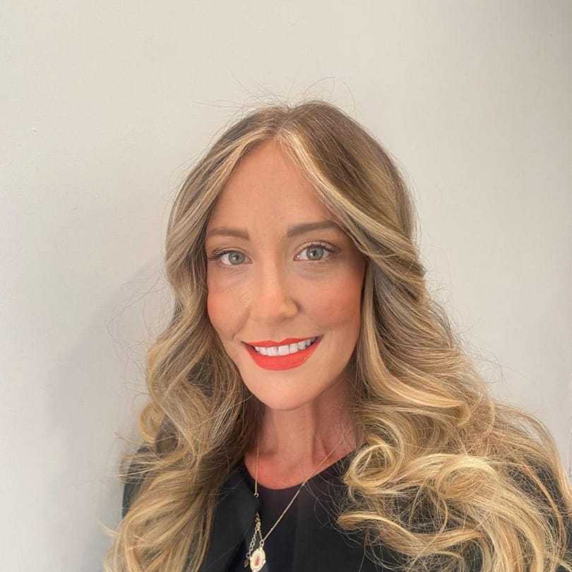 Portrait of Corinne, a professional stylist at [salon] 718, showcasing their expertise and style.