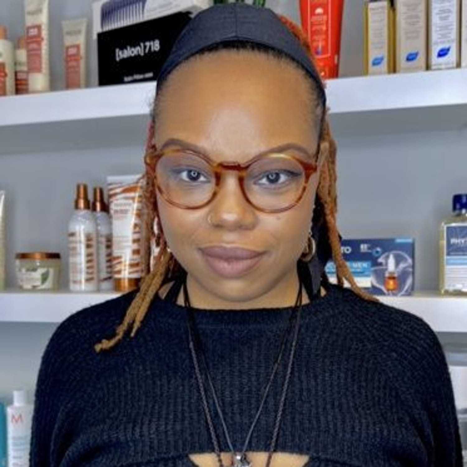 Portrait of Djenaba, a professional stylist at [salon] 718, showcasing their expertise and style.