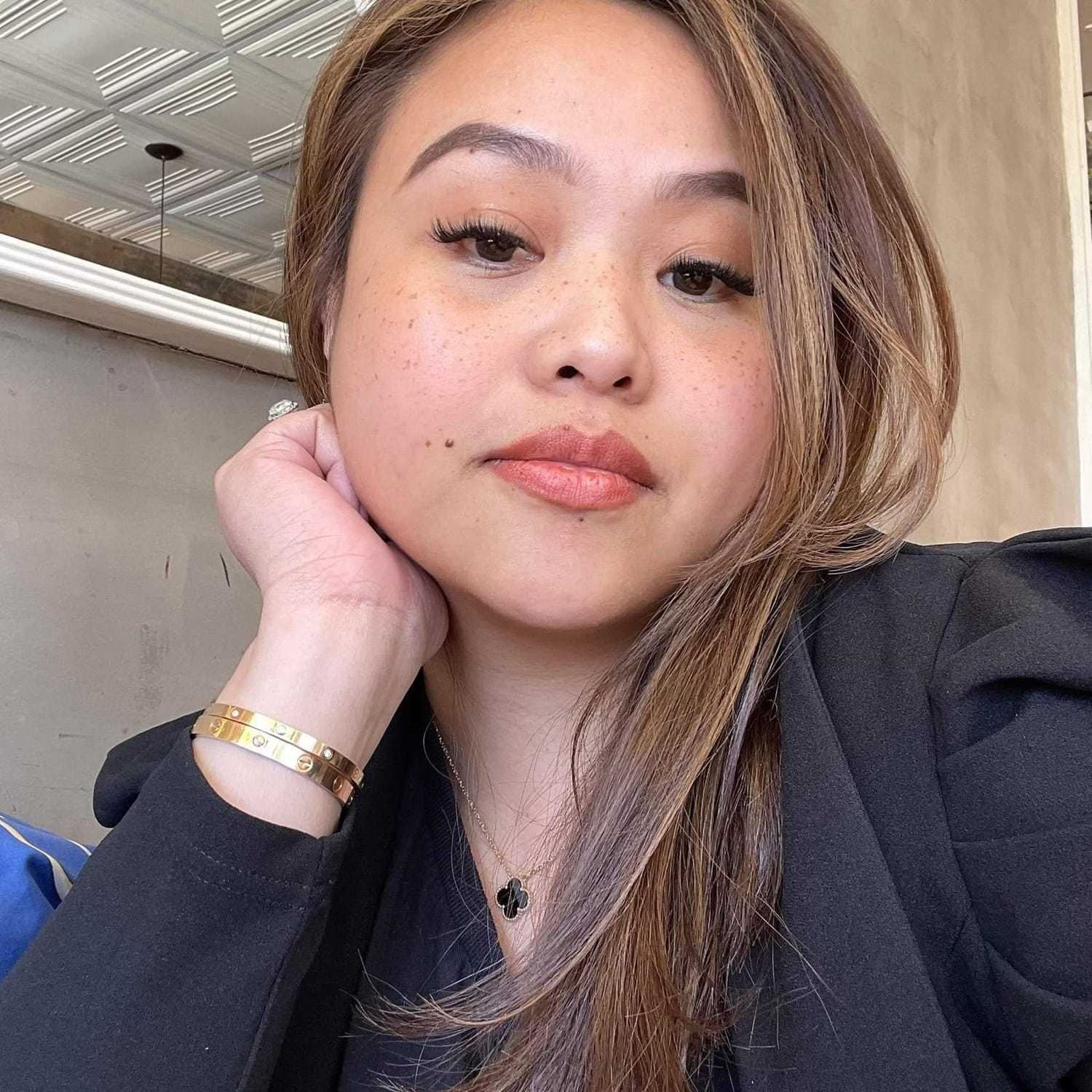 Portrait of Dhevie, a professional stylist at [salon] 718, showcasing their expertise and style.