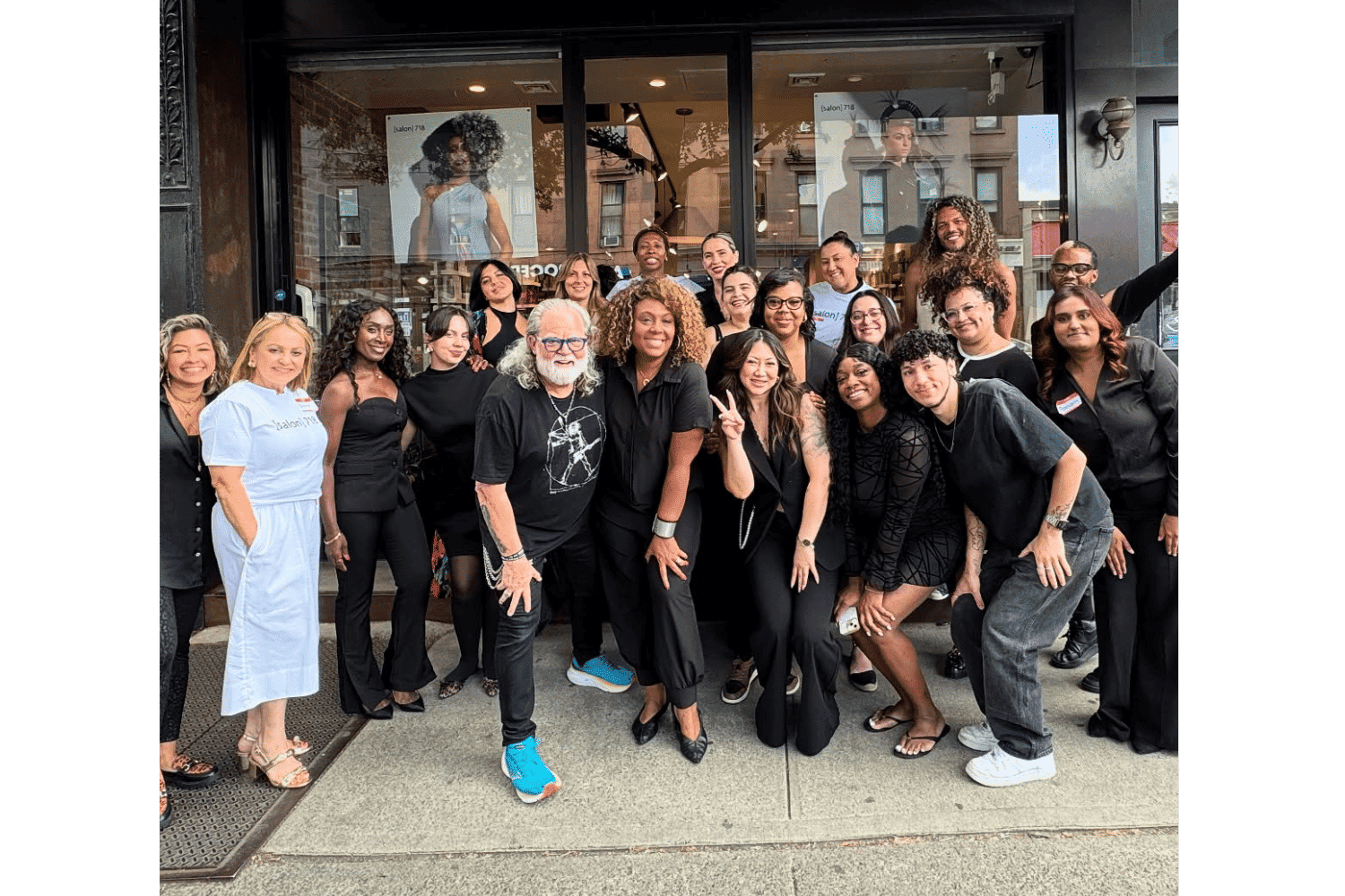Group of people in front of a store, posing and smiling at the camera.