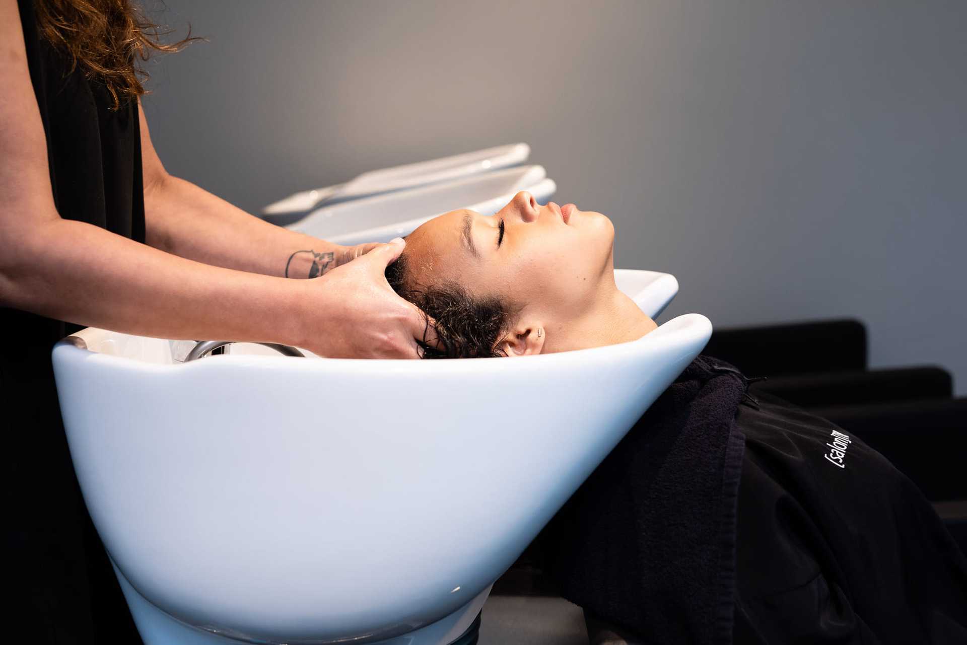 Person getting shampooed at a hair salon sink.